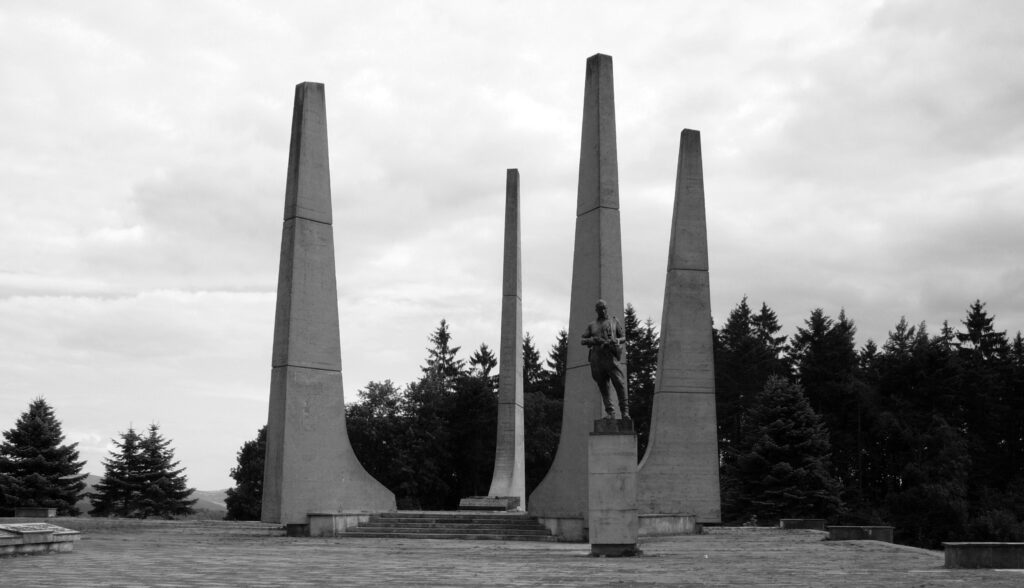 Památník doplněný o kopii sochy sovětského partyzána z pomníku padlým rudoarmějcům ve Zlíně od Vincence Makovského (1900–1966) – instalována 1985, deinstalována 2008 /foto Pornero, Wikimedia Commons, File:Ploština.jpg