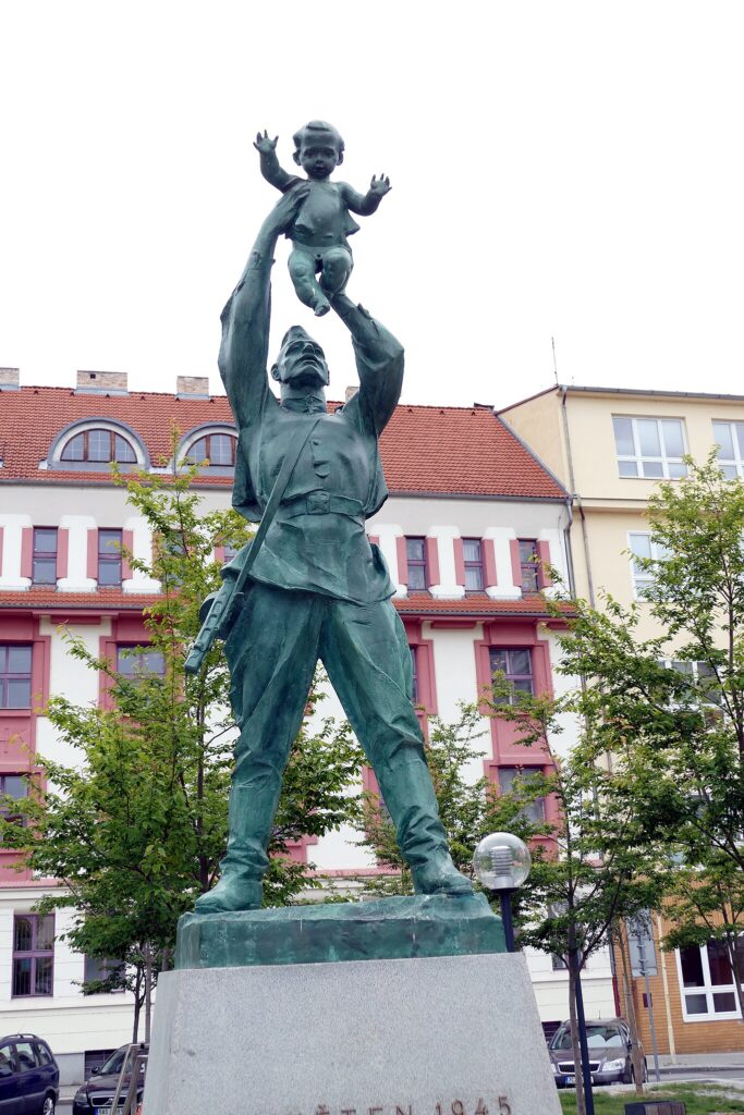 Tábor, Pomník Rudé armády z roku 1949. Sochař Luděk Varvažovský (1923–1949) ho do soutěže vyhlášené městským národním výborem v roce 1947 přihlásil pod názvem Vojna a mír. Oproti původním plánům byl pomník odhalen před budovou zemědělské školy místo sochy T. G. Masaryka /foto Donald Judge, Wikimedia commons File:16.7.20 Tabor 04 (50119691803).jpg