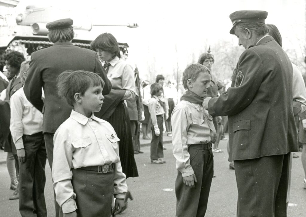 Šátkování pionýrů milicionáři před Památníkem osvobození v Trutnově v rámci májových oslav, 1980 /Státní okresní archiv Trutnov